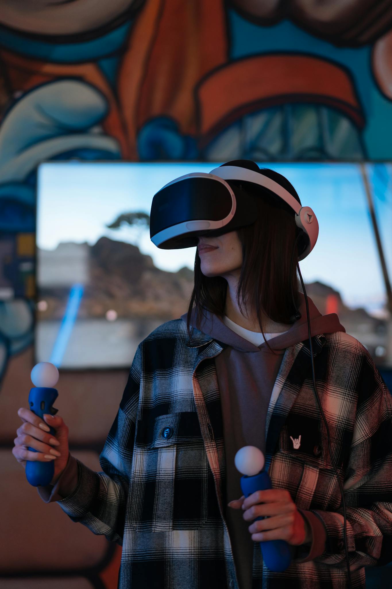 Young woman using VR headset and controllers, immersed in virtual reality gaming indoors.